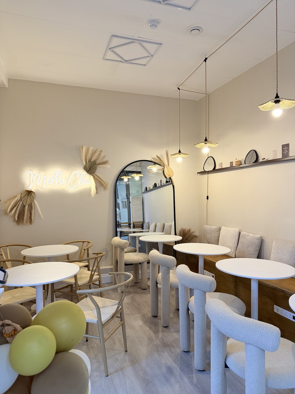 Mello cha's cosy seating area with tables, warm lighting and cushioned chairs